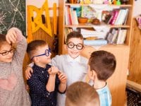Schoolchildren in fun glasses discus the lesson