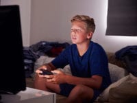 Teenage Boy Addicted To Video Gaming At Home